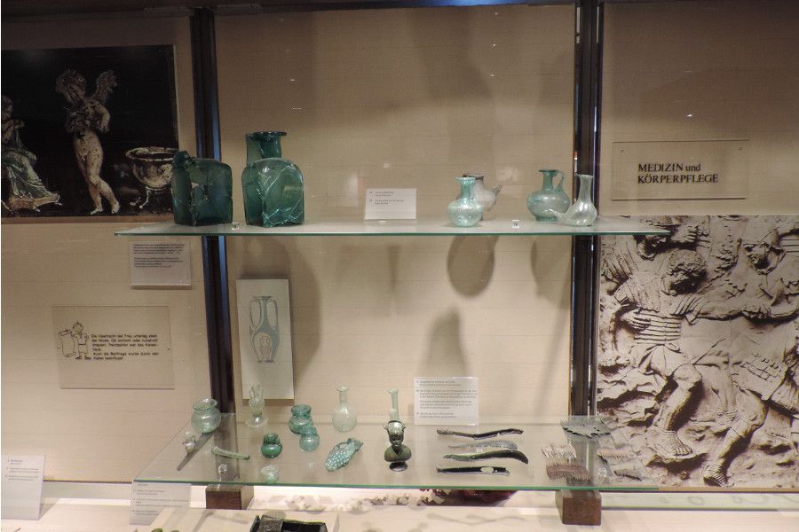 Glas war bei den Römern durchaus verbreitet. Sie nutzten es nicht nur für Schmuck oder Fensterscheiben, sondern auch in Form von oft sehr filigranen Gefäßen, wie z.B. als Trinkfläschchen für Säuglinge (rechts oben)